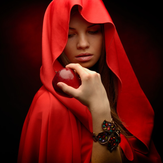 beautiful woman with red cloak hoding apple